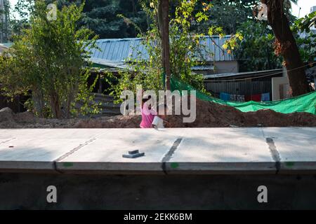 YANGON, MYANMAR - DEZEMBER 31 2019: Zwei junge burmesische Kinder spielen zusammen an einem Bahnhof außerhalb von Yangon Stockfoto