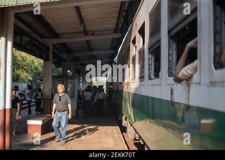 YANGON, MYANMAR - DEZEMBER 31 2019: Blick auf die burmesischen Einwohner bei einer Bahnsteigung während einer Fahrt mit dem traditionellen Kreiszug Stockfoto