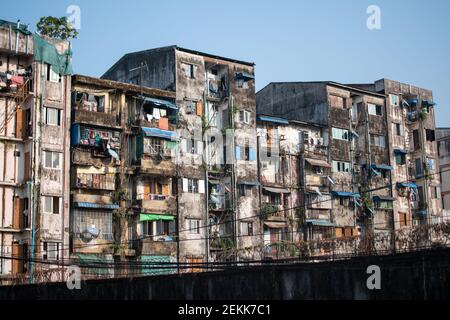 YANGON, MYANMAR - DECEMEBER 31 2019: Ein Betonwohnhaus in direkter Sonneneinstrahlung mit Balkonen unter dem blauen Himmel Stockfoto