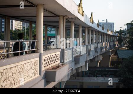 YANGON, MYANMAR - DEZEMBER 31 2019: Ein langer Fußweg mit Fußgängern über der Plattform für den traditionellen Kreiszug Stockfoto