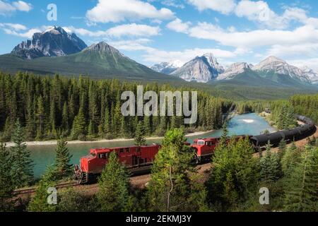 Roter Güterzug durch Morants Kurve in Bow Valley, Banff National Park, Alberta, Kanada. Stockfoto