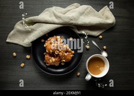 Donuts und schwarzer Kaffee auf rustikalem Hintergrund. Stockfoto