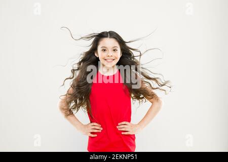 Perfekte locken. Kind süß Gesicht mit adorable curly Frisur. Kleines Mädchen lange Haare wachsen. Teen Mode Modell. Unterschied entdecken. Styling lockiges Haar. Friseur Tipp. Kind Mädchen lange gesund glänzendes Haar. Stockfoto