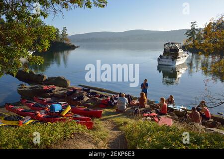 Gruppe von Kajakfahrern am Strand in Conover Cove, Wallace Island, Gulf Islands, British Columbia, Kanada Stockfoto