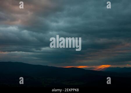 Strahlen von strömendem Licht scheinen von den oben Wolken während Sonnenuntergang über den Blue Ridge Mountains in Virginia Stockfoto