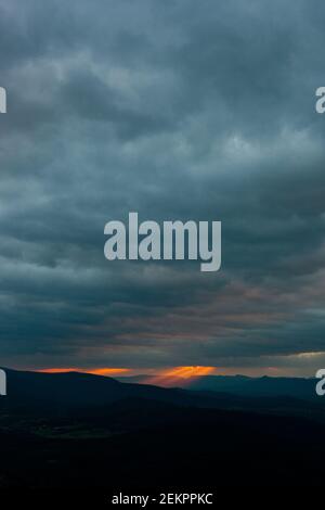 Strahlen von strömendem Licht scheinen von den oben Wolken während Sonnenuntergang über den Blue Ridge Mountains in Virginia Stockfoto