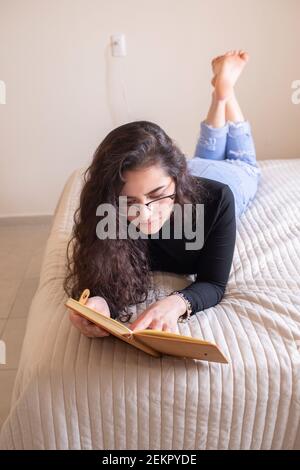 Junge Frau im Bett studieren Stockfoto