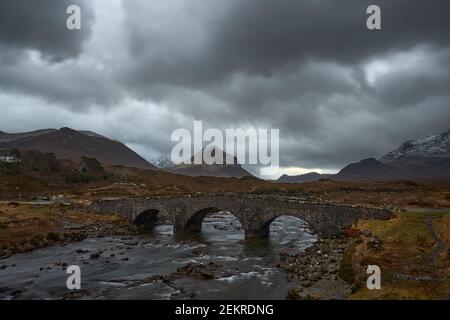 Alte drei gewölbte Steinbrücke über den Fluss Sligachan in Isle of Skye Schottland mit Cuillin Bergkette in der Ferne, Isle of Skye, Schottland Stockfoto
