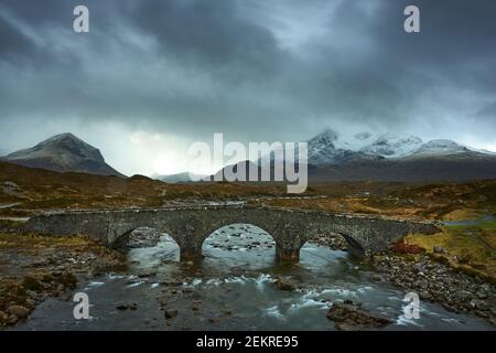 Alte drei gewölbte Steinbrücke über den Fluss Sligachan in Isle of Skye Schottland mit Cuillin Bergkette in der Ferne, Isle of Skye, Schottland Stockfoto