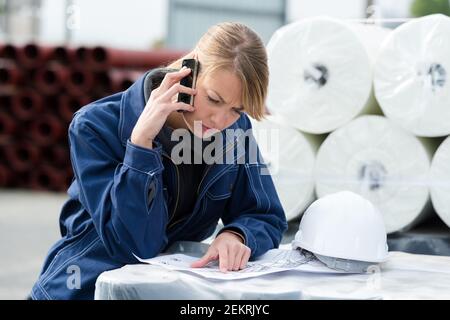 Geschäftsfrau mit Mobiltelefon außerhalb des Lagers Stockfoto