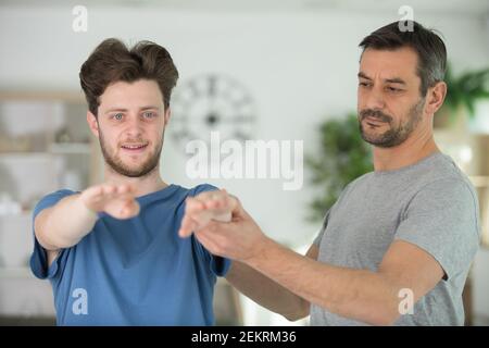 Yoga-Lehrer hilft Anfänger Stretching-Übungen zu machen Stockfoto