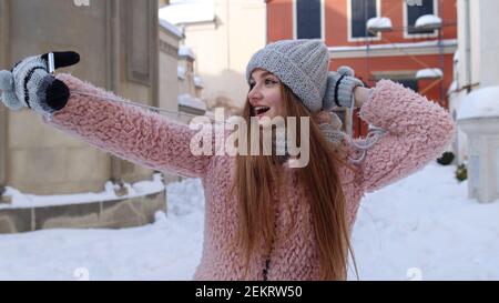 Junge Reisende Brünette Frau blogger macht Selfies Foto-Bilder für soziale Netzwerke auf Handy auf Stadt Straße. Mädchen macht Videoanruf, chatten mit Freunden, Fernkommunikation, vlogger Stockfoto