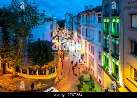 Nachtansicht von einem Fenster in der oberen Etage mit Blick auf eine geschäftige Straße in Istanbul, Türkei, mit der Bosporus-Brücke und Ortaköy Moschee beleuchtet. Stockfoto