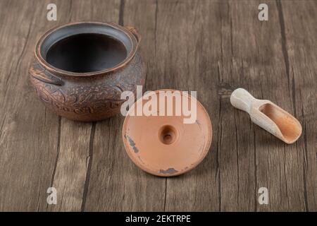 Uralter Topf mit einem Holzlöffel auf einem Holztisch Stockfoto