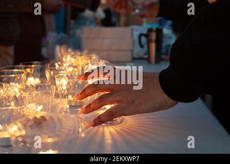 Washington, DC, USA, 23. Februar 2021. Im Bild: Eine Frau nimmt eine Kerze vor einer Kerzenlichtmahnwache zum ersten Jahrestag des Todes von Ahmaud Arbery. Arbery, ein schwarzer Mann, wurde während des Joggens von zwei weißen Männern in Glynn County, Georgia, ermordet. Kredit: Allison C Bailey/Alamy Live Nachrichten Stockfoto