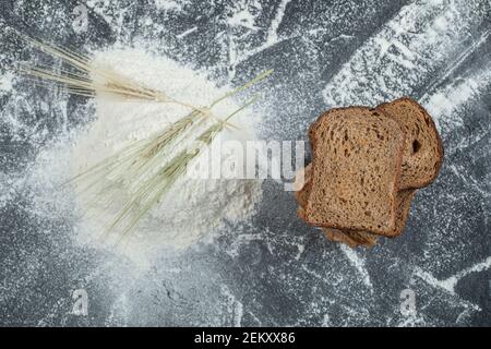 Scheiben braunes Brot mit Mehl auf einem bunten Hintergrund Stockfoto