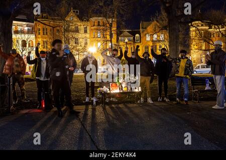 Washington, DC, USA, 23. Februar 2021. Im Bild: Schwarze Männer, die bei der Kerzenlichtmahnwache zum ersten Jahrestag von Ahmaud Arberys Todesstand anwesend waren, mit Fäusten, die hinter dem Denkmal für die Veranstaltung erhoben wurden. Arbery wurde beim Joggen von zwei weißen Männern in Glynn County, Georgia, getötet. Kredit: Allison C Bailey/Alamy Live Nachrichten Stockfoto