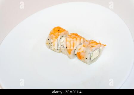 Sushi-Brötchen mit Garnelen und Frischkäse liegen auf weißem Teller. Japanische Küche, europäische Sushi-Brötchen Stockfoto