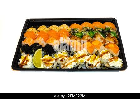 Sushi-Set mit Rollen philadelphia, kalifornien, Bonito, Thunfisch, Sesam, Schwarzer Tobico, chuka-Salat, Garnelen und Frischkäse liegen zur Lieferung in einer schwarzen Box Stockfoto