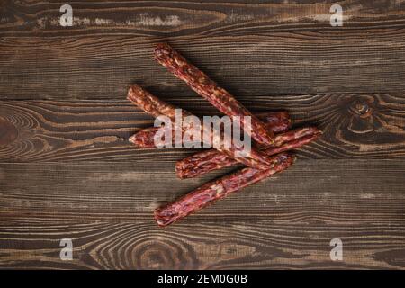 Blick von oben auf getrocknete, jerked Hirsch und Schweinewurst Holzhintergrund Stockfoto