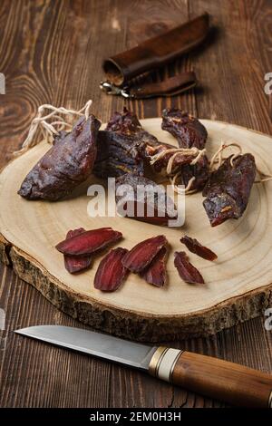 Blick von oben auf getrocknete gerockte Hirsche oder Wildfleisch Holzhintergrund Stockfoto