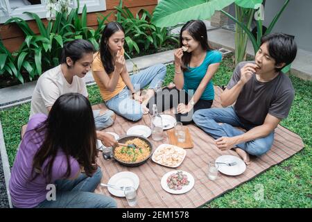 Gruppe asiatischer Freunde, die Spaß beim Essen und Trinken haben Im Hinterhof - Glückliche Menschen zusammen Stockfoto