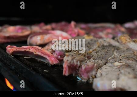 Seltene Rindfleisch-Küche auf einem gasbetriebenen Grill in einem Haus in Sydney, Australien mit Orangenfeuer, das unter dem Grill ausleckt Stockfoto