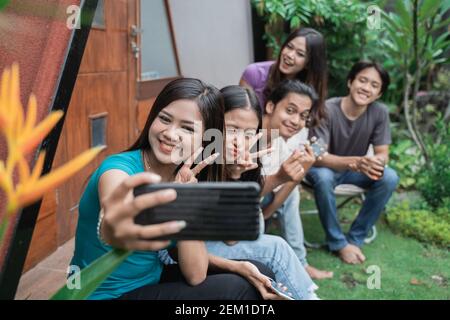 Gruppe asiatischer Freunde, die Spaß beim Essen und Trinken haben Im Hinterhof - Glückliche Menschen bei Gartenparty Stockfoto