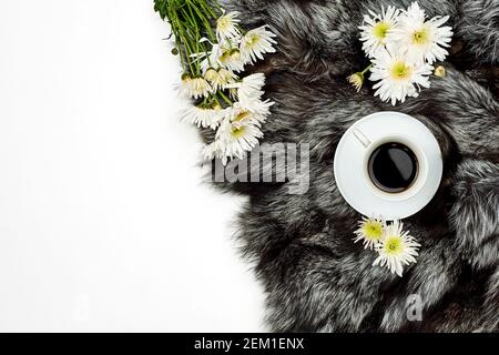 Draufsicht auf eine Tasse heißen schwarzen Kaffee Pelzteppich mit weißen Blüten Stockfoto