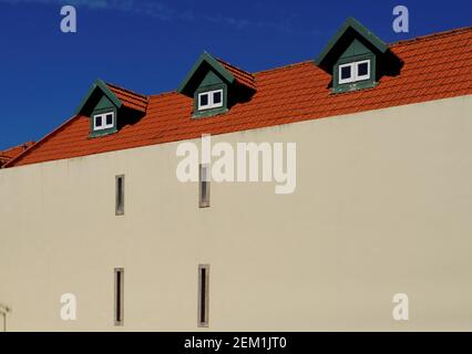 Ein Haus mit rotem Ziegeldach und drei Türmchen Stockfoto