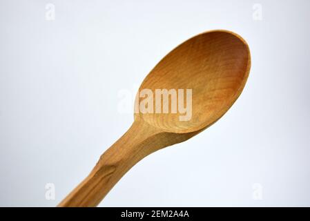 Produkte aus natürlichem handgefertigtem Baum. Großer Holzlöffel mit Schnitzereien. Schöne und ungewöhnliche Dinge auf weißem Hintergrund. Stockfoto