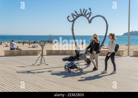 Palmanova, Spanien; februar 20 2021: Seepromenade der mallorquinischen touristischen Ortschaft Palmanova, mit einer eisernen Herzskulptur. Fußgänger gehen zu Fuß Stockfoto