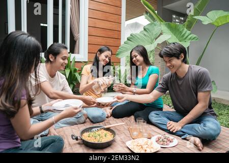 Gruppe asiatischer Freunde, die Spaß beim Essen und Trinken haben Im Hinterhof - Glückliche Menschen bei Gartenparty Stockfoto