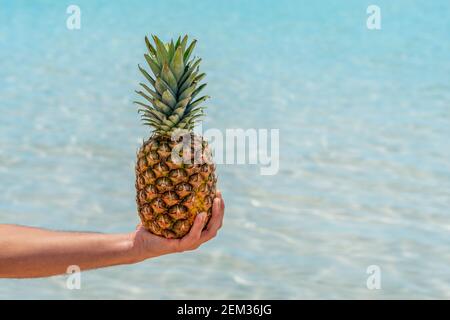 Mann hält Ananas auf Meeresgrund. Urlaub und Reisekonzept.