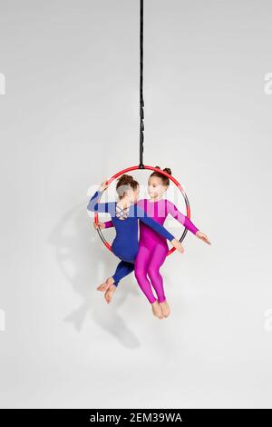 Zwei kleine Mädchen zeigt eine akrobatische Performance auf einem Luftreifen. luftakrobatin Stockfoto