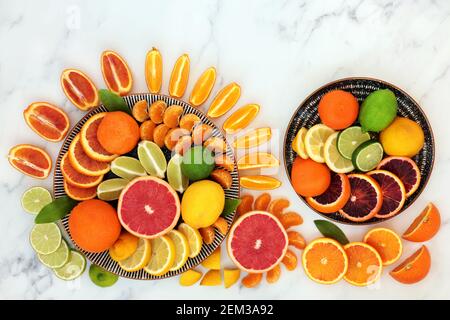 Köstliche frische Zitrusfrüchte auf Tellern & lose hoch in Antioxidantien & Vitamin C, Anthocyane, Lycopin & Ballaststoffe. Stockfoto