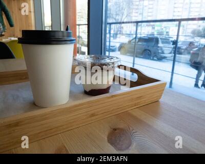 Gesundes sonntagsfrühstück mit Kaffee und Schale hausgemachtem Müsli Mit Joghurt auf einem Holztablett in einem Café Stockfoto