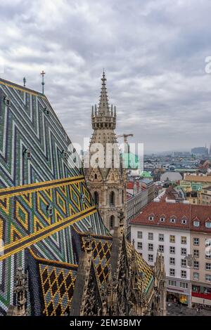 Luftaufnahme über die Dächer der Stadt Wien vom Nordturm des Stephansdoms mit dem berühmten kunstvoll gemusterten Dach des Doms. Stockfoto