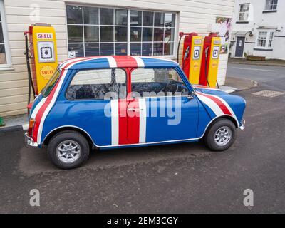 Vintage Austin Mini in Union Jack Farben vor alten Shell Benzinpumpen, Patishall, Northamptonshire, UK Stockfoto