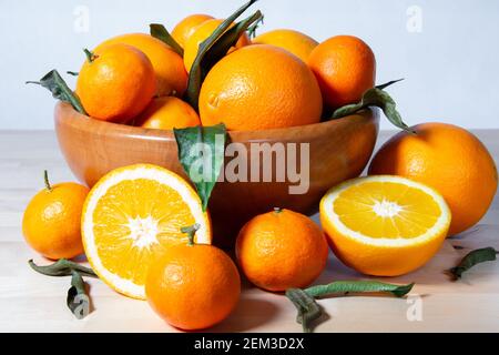 Einige Orangen in einem Korb über einer hölzernen Oberfläche Stockfoto