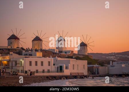 Mykonos, Griechenland - 02. Oktober 2011: Blick auf Windmühlen bei Sonnenuntergang, mit Besuchern, auf Mykonos Insel, Griechenland Stockfoto