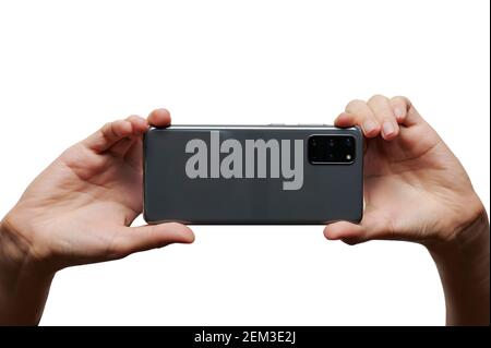 Fotografieren Sie mit einer mobilen Kamera in zwei Händen isoliert Auf weißem Studiohintergrund Stockfoto