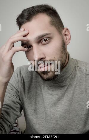 Porträt eines jungen Mannes, der seine Stirn in einem berührt Moment der Inspiration Stockfoto