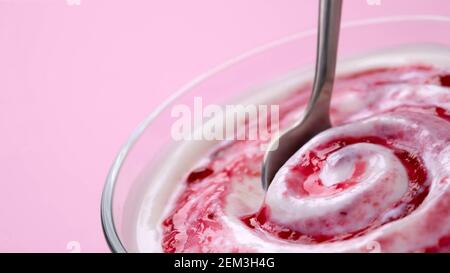 Joghurt mit Beerenmarmelade im Löffel, Heidelbeere Schlagsahne Stockfoto