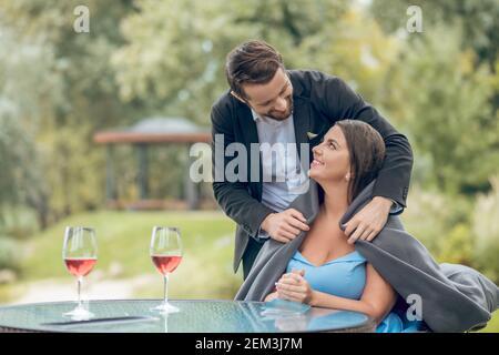 Mann, der Frau im Café im Freien mit Plaid bedeckt Stockfoto