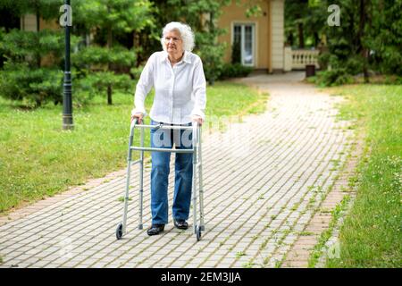 Ältere Frau mit Wanderausrüstung, um ihr mit einem zu helfen parkbummel Stockfoto