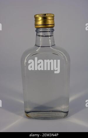 Klassische Glasflasche von 500 ml mit schwellendem Hals und vergoldeten Deckel für alkoholische und starke Getränke auf weißem Hintergrund. Stockfoto