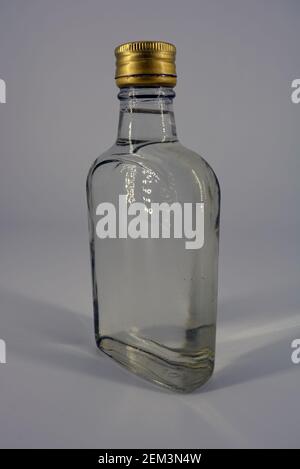 Klassische Glasflasche von 500 ml mit schwellendem Hals und vergoldeten Deckel für alkoholische und starke Getränke auf weißem Hintergrund. Stockfoto