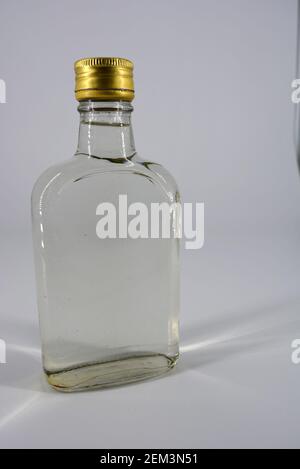 Klassische Glasflasche von 500 ml mit schwellendem Hals und vergoldeten Deckel für alkoholische und starke Getränke auf weißem Hintergrund. Stockfoto