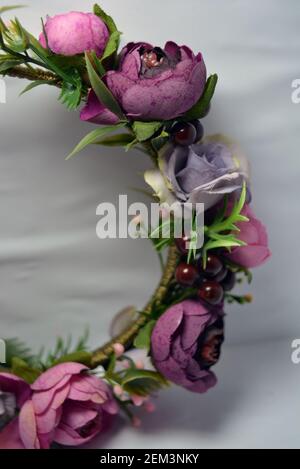 Ein schöner Haarreifen aus schönen Pfingstrosen und kleinem Grün auf weißem Hintergrund. Stockfoto